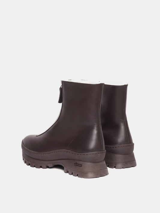 Brown fur-lined boots with a zipper going down the middle and brown vibram soles