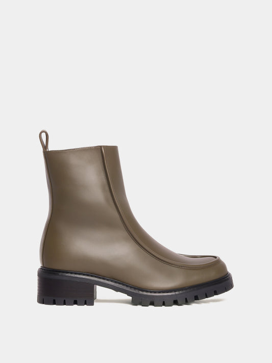 Shearling lined winter boot with a front piping detail, in an olive green leather with a black lug outsole. 