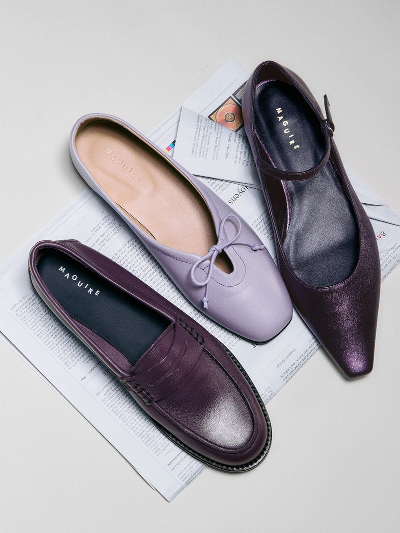 Pair of purple and lavender shoes on a newspaper background