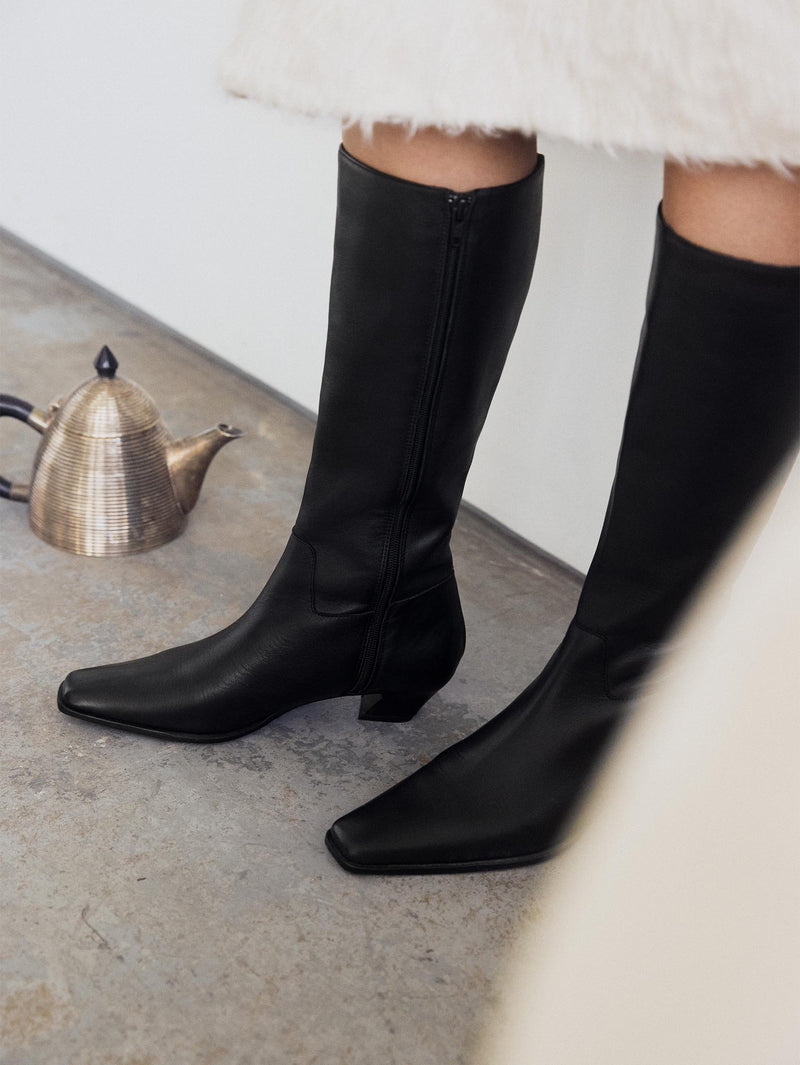 Close up on black boot with pointy toes